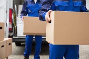 Close-up Of Two Mover’s Hand In Uniform Carrying Cardboard Box Movers Servicing The Entire Apache Junction Area