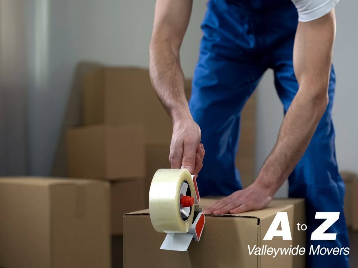A to Z Valley Wide Movers worker packing cardboard boxes