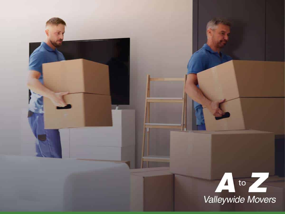 Two movers from A to Z Valleywide Movers carrying cardboard boxes in preparation for moving service