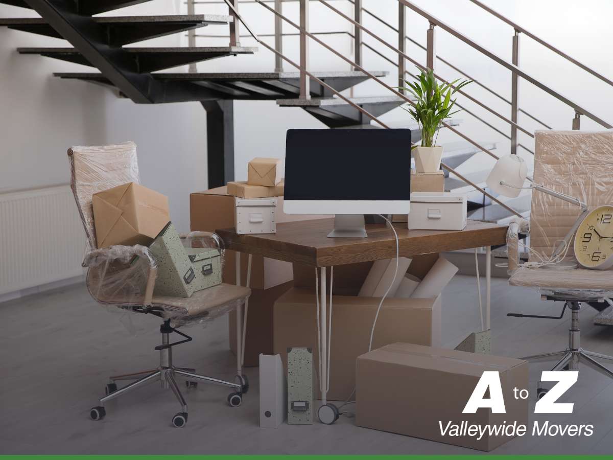 Corporate office move in progress with packed boxes and covered office equipment